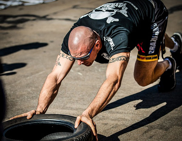 tyre-push Мужчина толкает покрышку